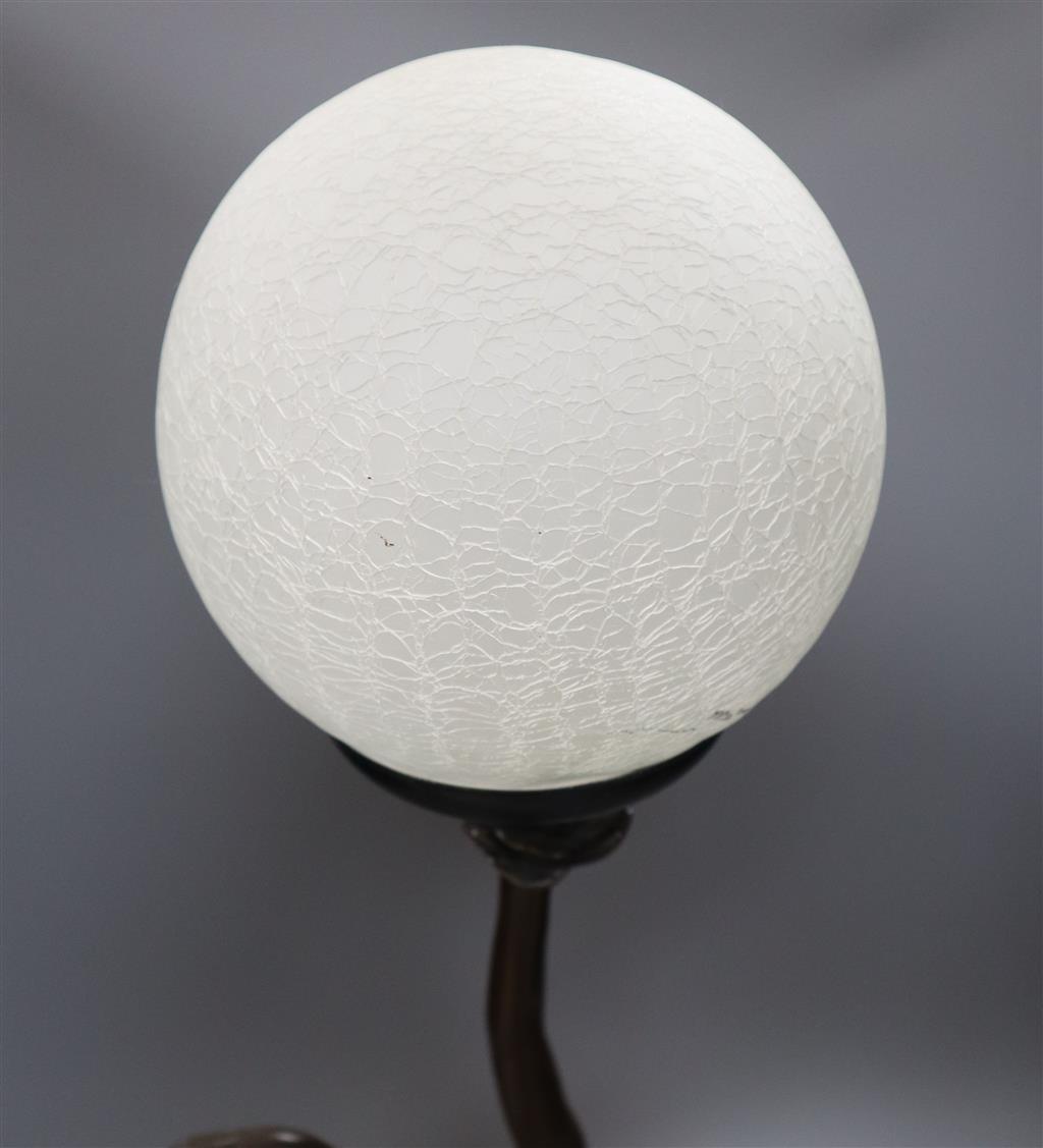 An Art Deco style bronzed resin figural table lamp, semi-nude female holding glass shade aloft, 66cm overall